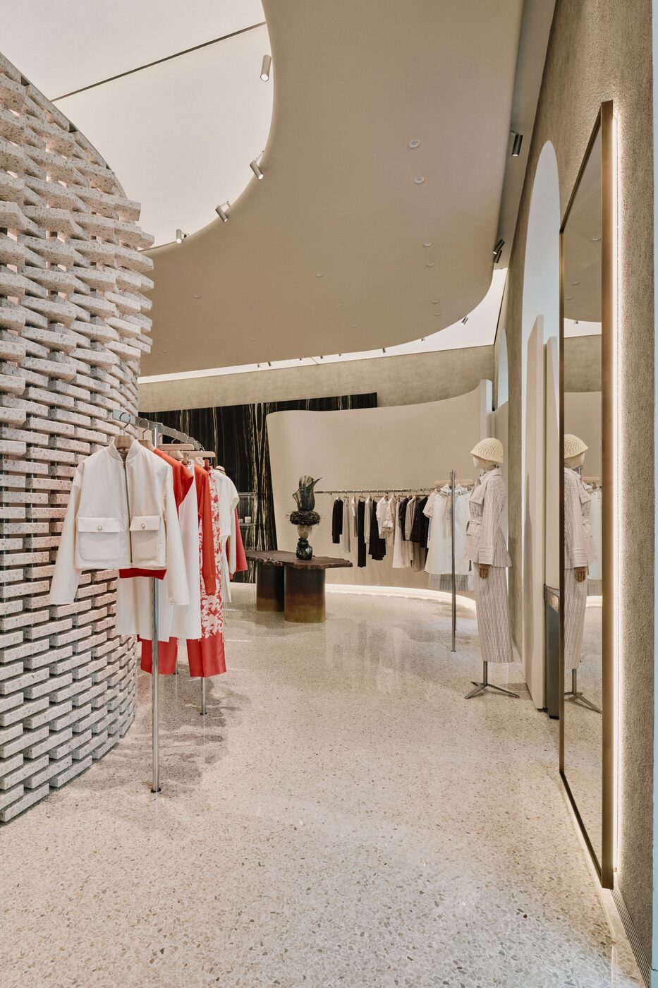 Detail of the burl-wood table and brick screen at the Agnona Milan flagship
