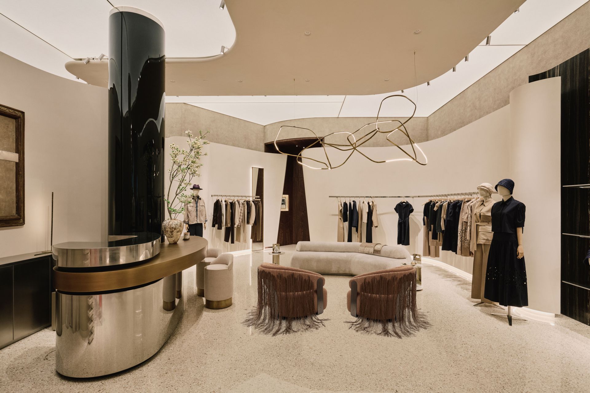 Interior of Agnona's new Milan flagship at via Santo Spirito 12, with brick screen and brass chandelier
