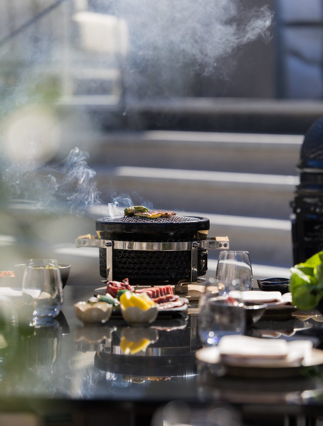 Smoke rising from a tableside yakiniku grill at Aman Le M&eacute;l&eacute;zin, Courchevel
