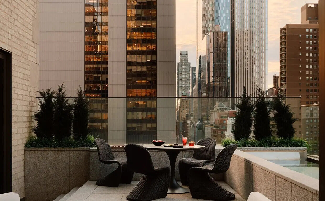 The private terrace and pool of the Two-Bedroom Home at Aman New York at dusk, Midtown towers beyond