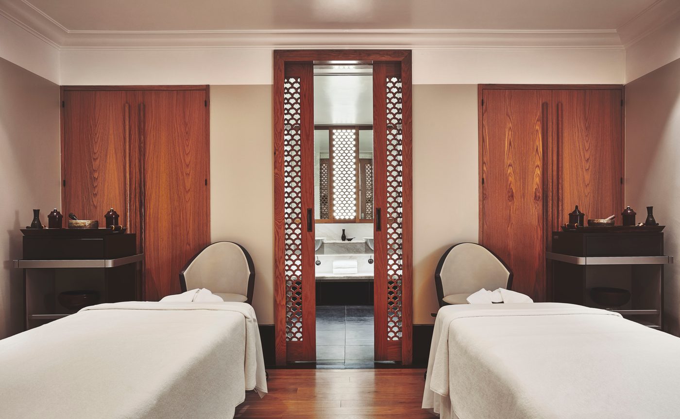 The couples' treatment room at Aman Spa at The Connaught, two beds facing a pierced timber screen that slides open to a bath, courtesy of Aman