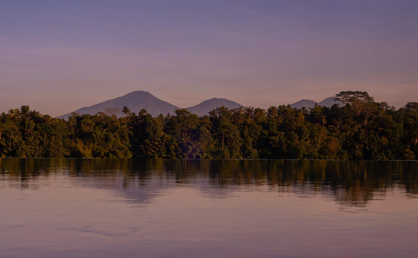 Amandari's infinity pool at dusk above the Ayung River Gorge with Mount Agung beyond, courtesy of Aman