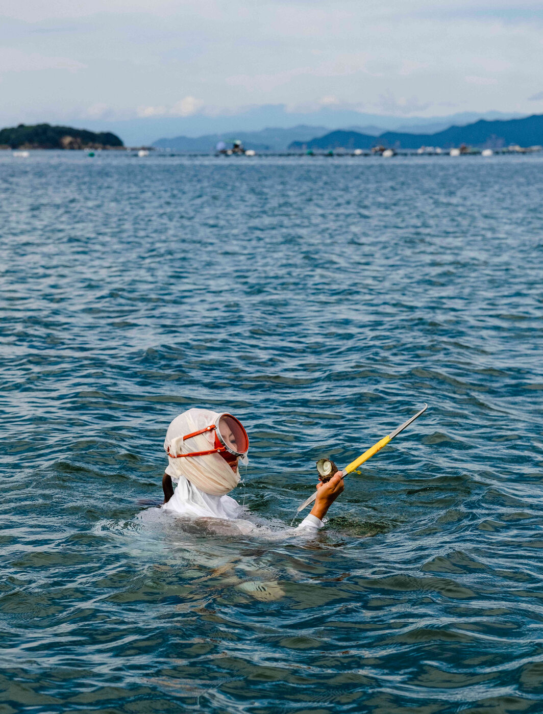 An ama diver in traditional white clothing in the waters of Ago Bay near Amanemu