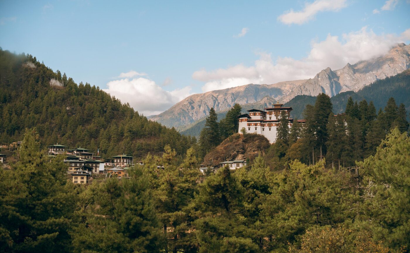 A Bhutanese dzong above a village in the Paro valley, with mountains beyond