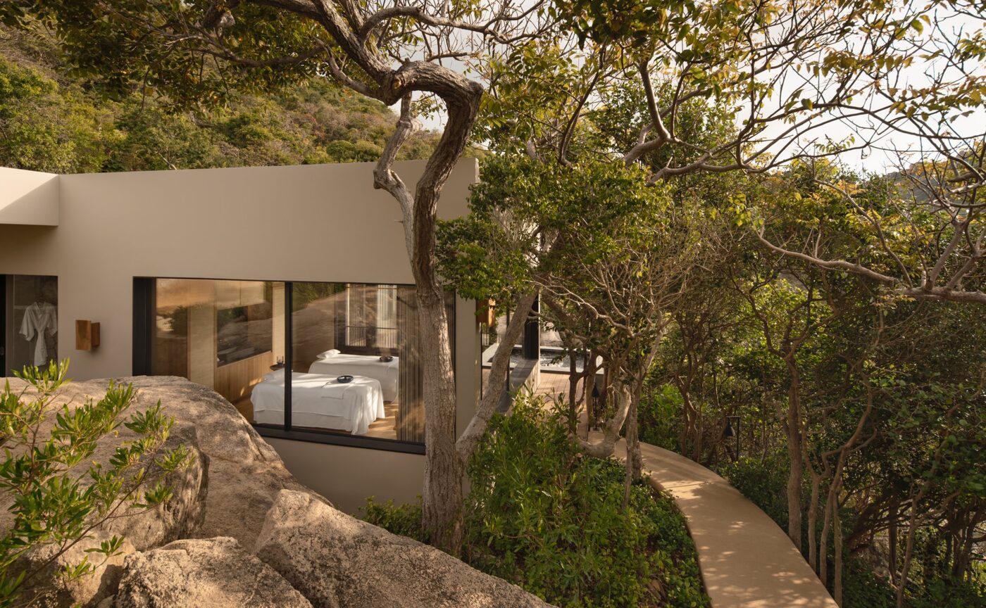 The private spa house of the Amanoi Ocean Pool Residence framed by mature trees above the Vietnamese coastline
