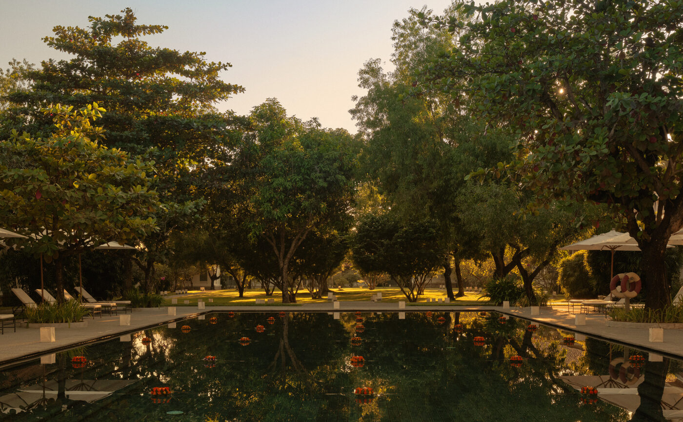 Marigold floats and paper lanterns on the main pool at Amantaka, Luang Prabang, at dusk during the festival of lights, courtesy of Aman