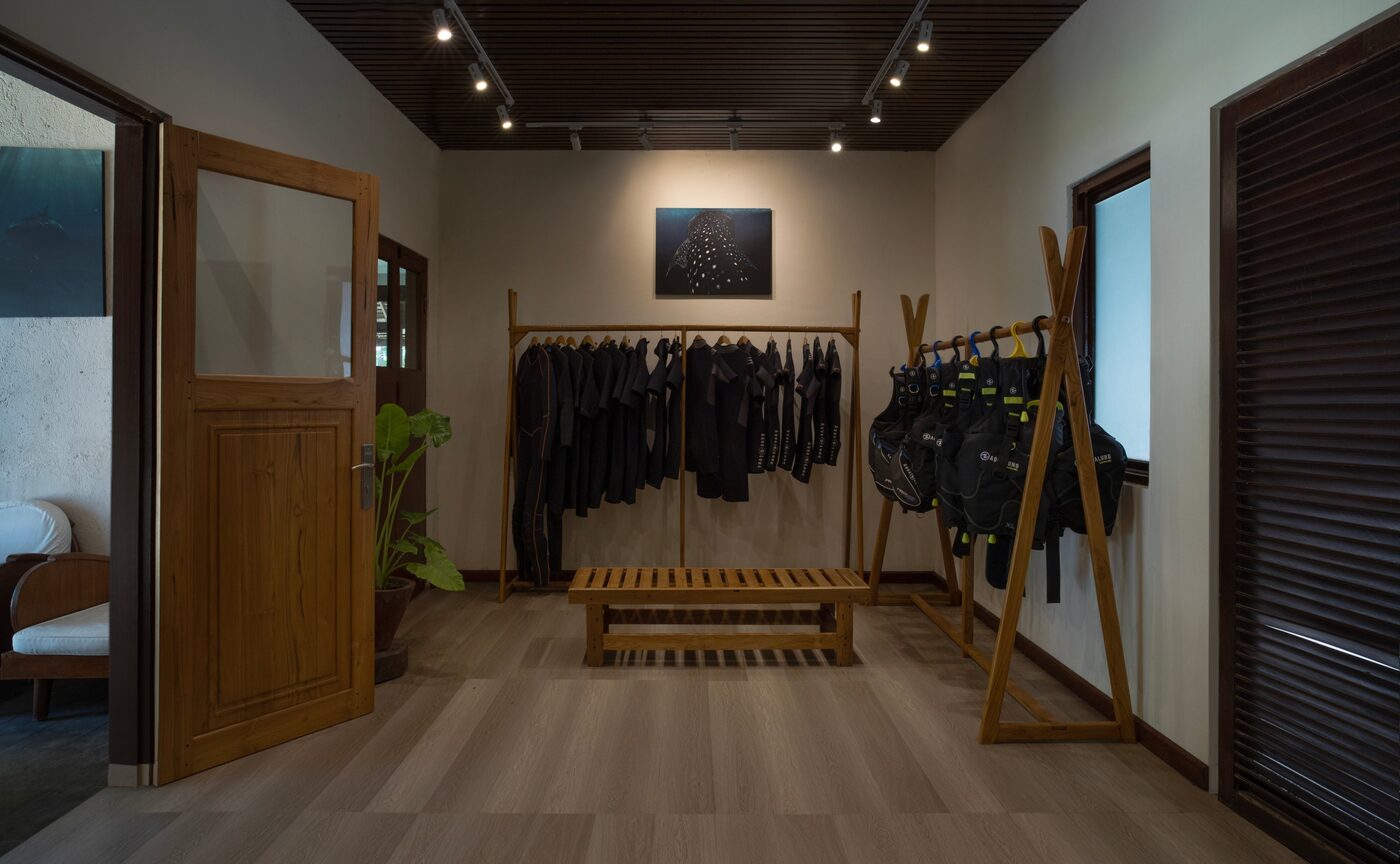 The dive centre interior at Amanwana with wooden flooring and racks of diving equipment