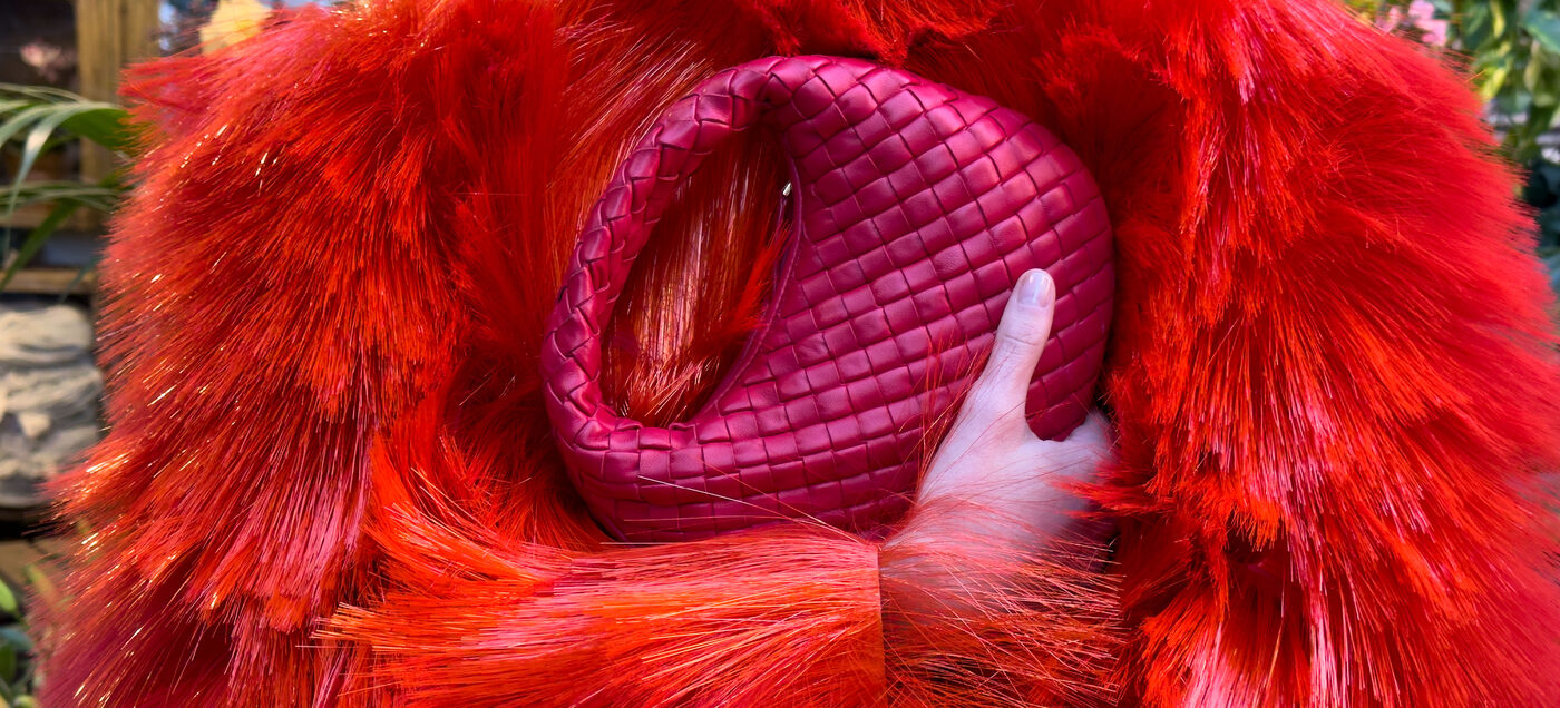 Bottega Veneta Winter 2026 campaign, an intrecciato bag held against red fringe, photographed by Juergen Teller in Milan