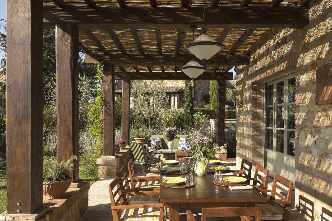 A pergola-shaded dining terrace at one of the new villas at Castello di Casole, A Belmond Hotel, Tuscany