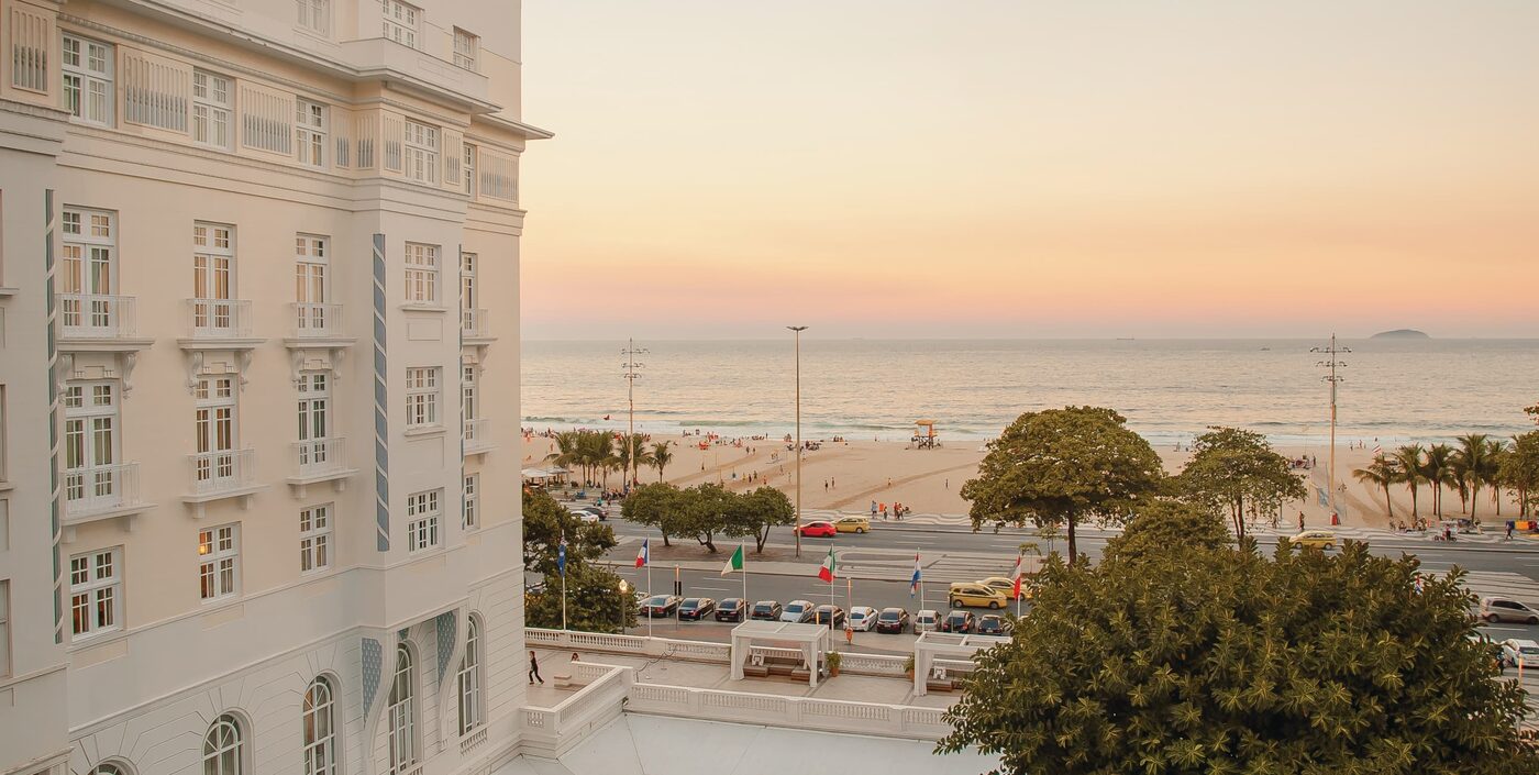 The white facade of the Copacabana Palace above Avenida Atlantica and Copacabana Beach at dusk
