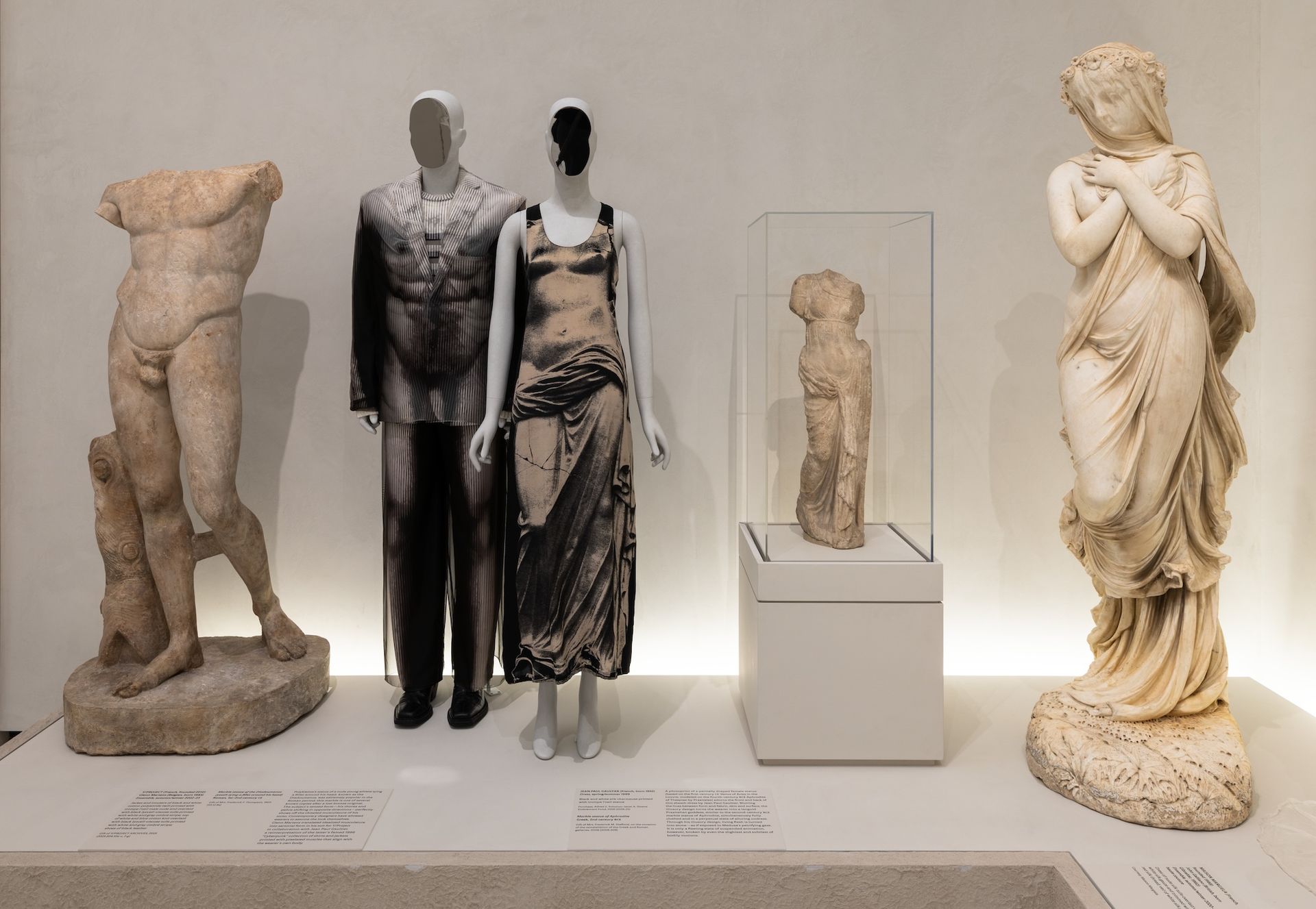 Inside the Costume Art exhibition at the Metropolitan Museum of Art, garments displayed on bespoke mannequins scanned from real bodies and topped with mirrored steel heads by Samar Hejazi