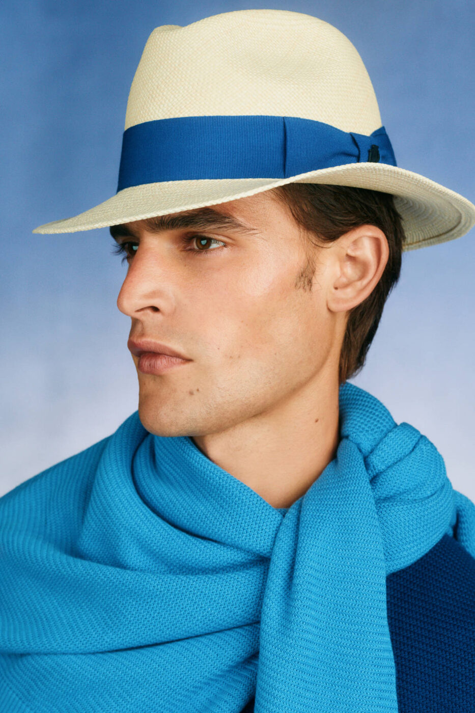 Dunhill Spring/Summer 2027, a straw panama with a blue band and a turquoise knit scarf