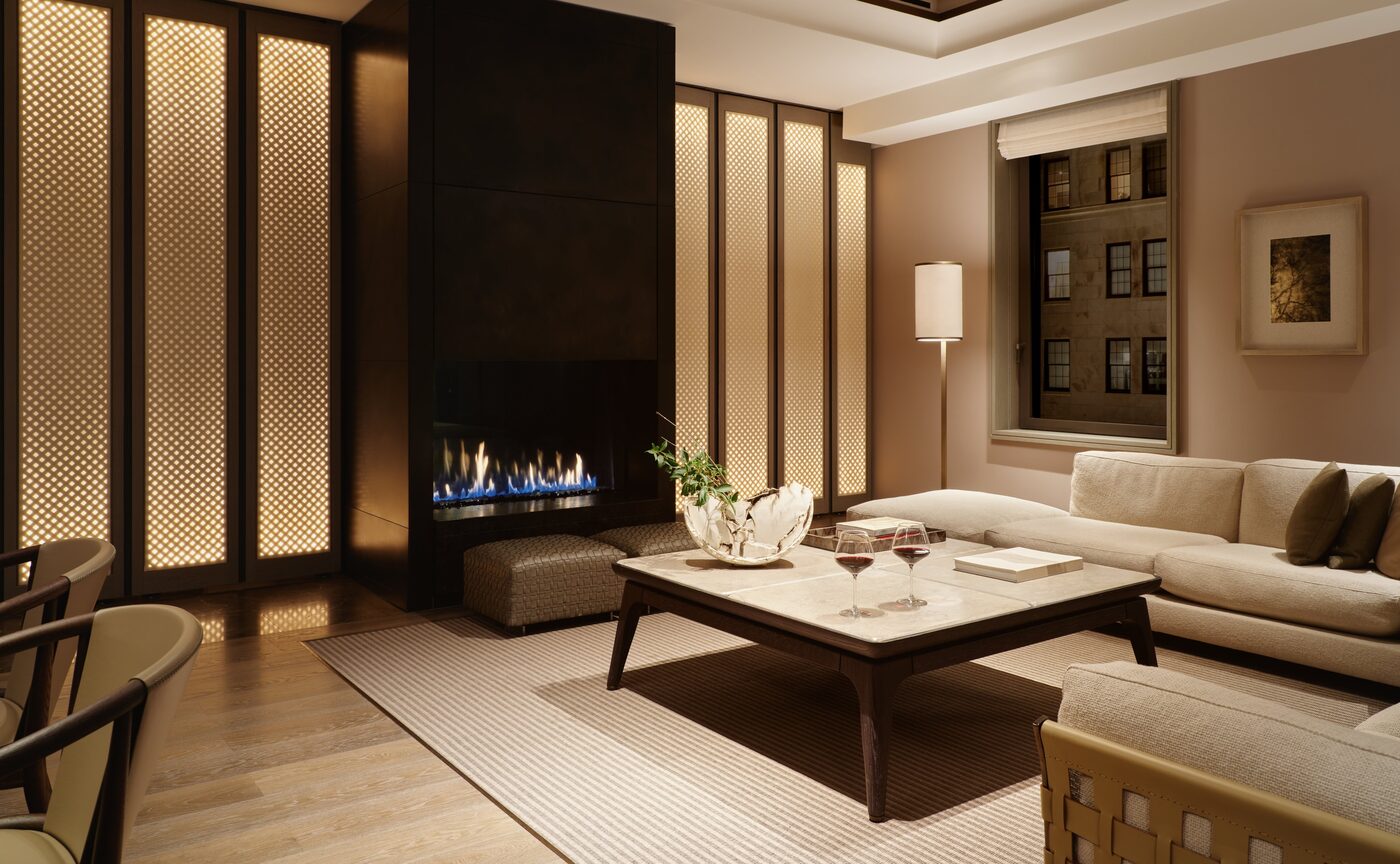The living room of a Corner Suite at Aman New York in the evening