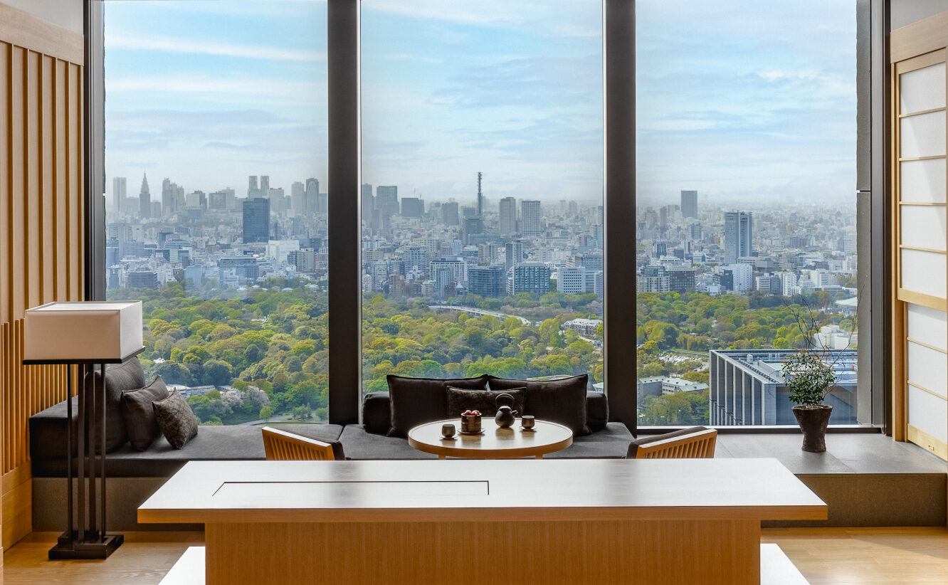A suite at Aman Tokyo with floor-to-ceiling windows over the Imperial Palace gardens and the Shinjuku skyline, courtesy of Aman