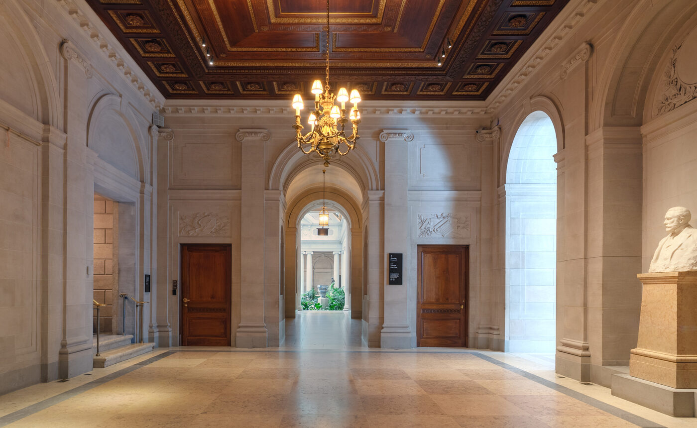 A restored interior gallery of The Frick Collection following the 2025 Selldorf Architects renovation, showing original damask walls and gilded fixtures