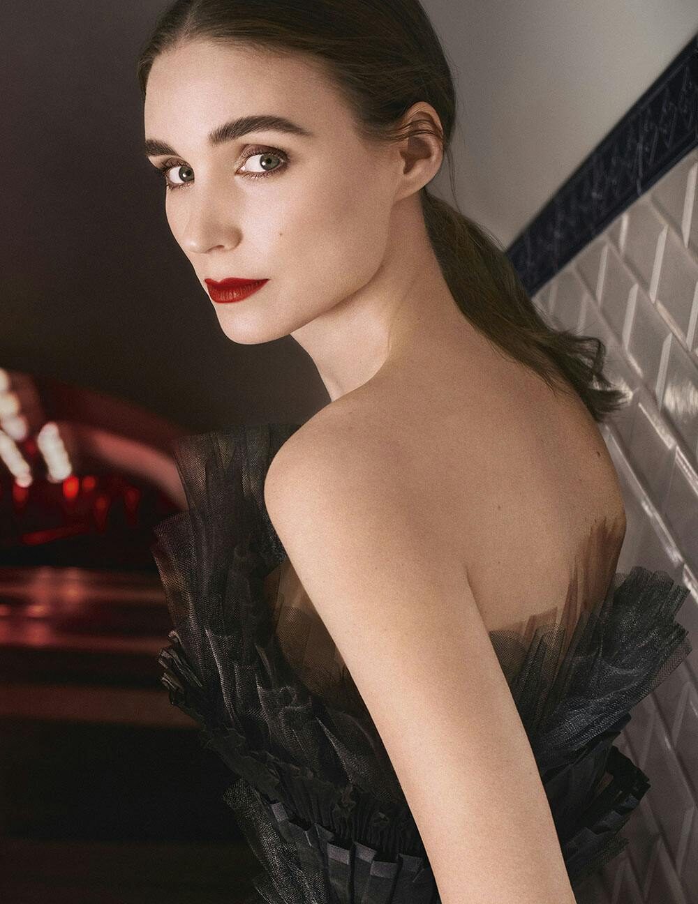 A Givenchy campaign portrait from the Sarah Burton era, shot against a red-lit interior