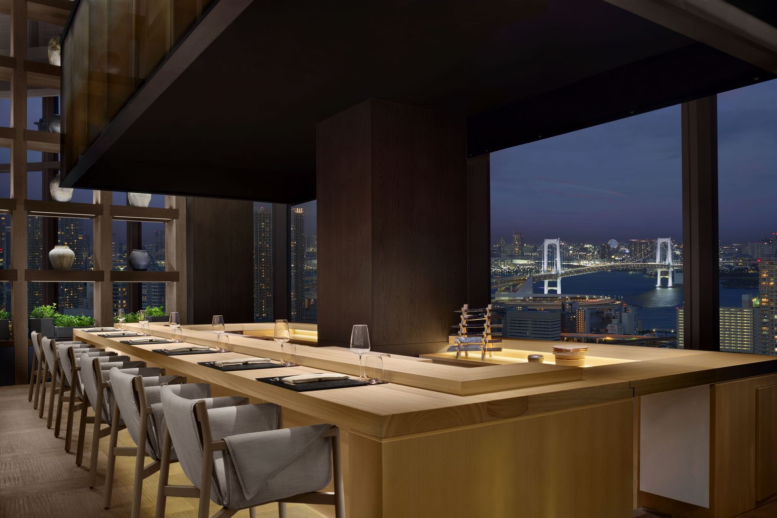 The omakase counter at JW Marriott Hotel Tokyo with Rainbow Bridge visible at night through floor-to-ceiling windows