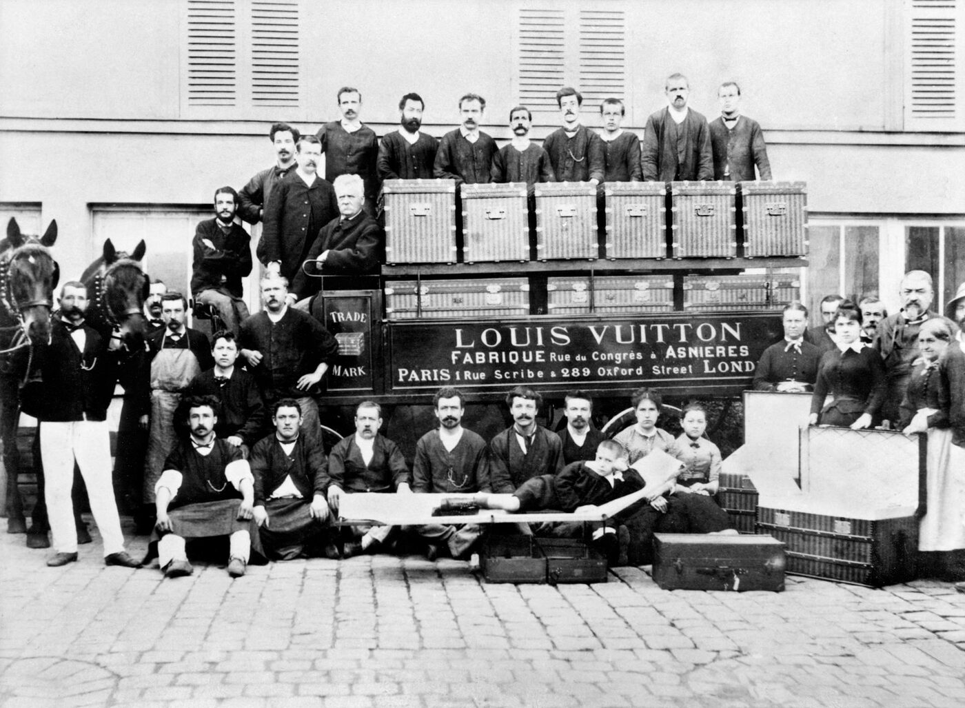 Staff of the Louis Vuitton workshop at Asnières posed with trunks and house signage in an early photograph