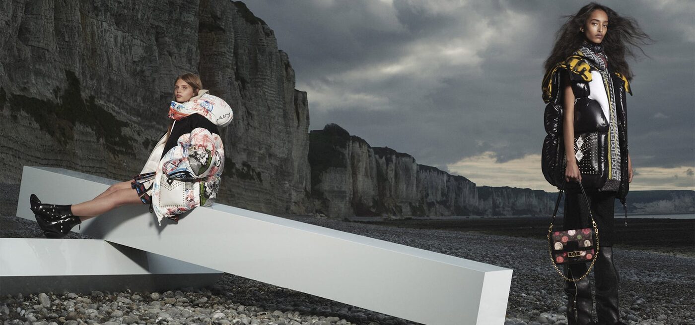 A Louis Vuitton campaign image shot on a stretch of chalk coastline under a heavy sky