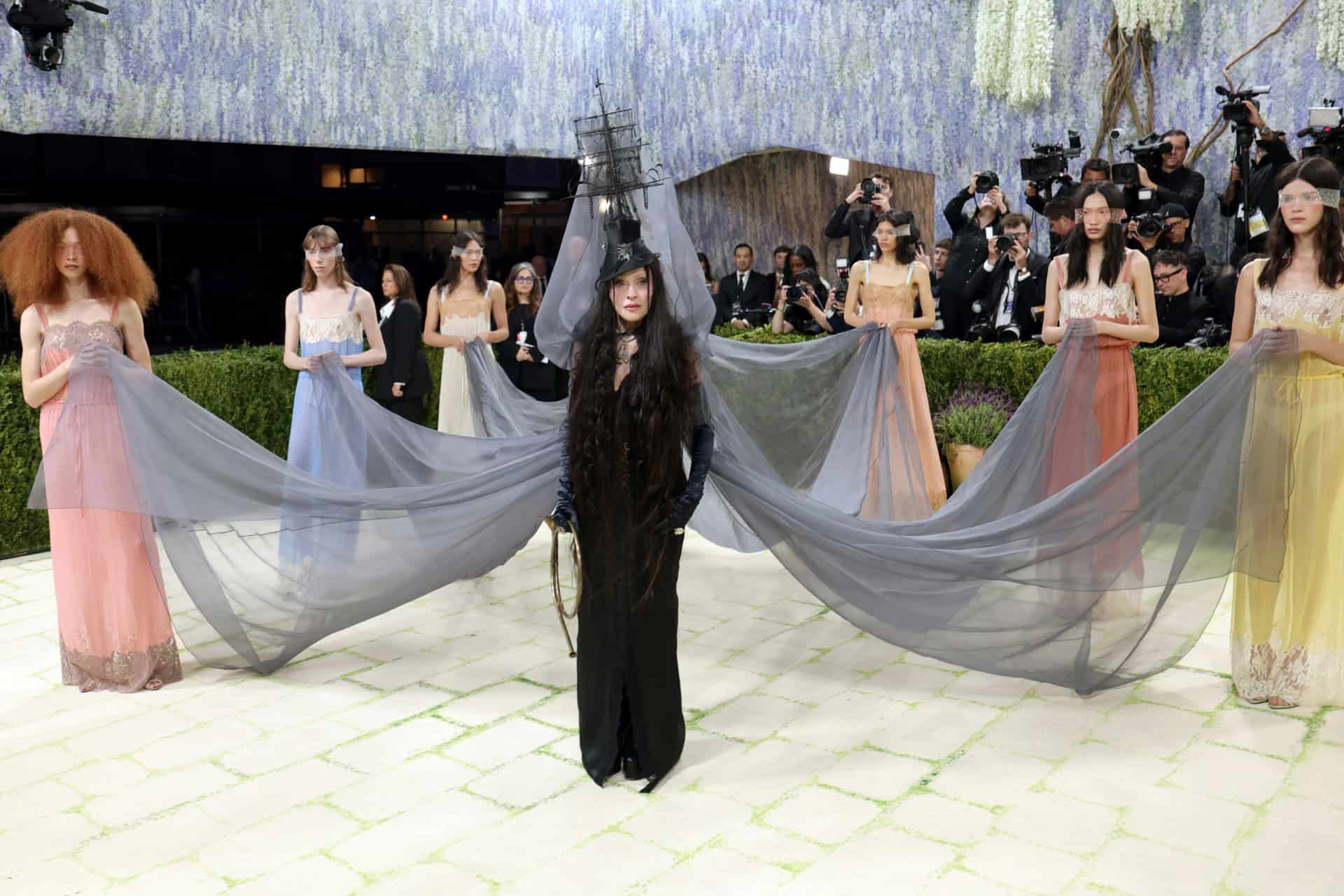 Madonna at the 2026 Met Gala in custom Saint Laurent designed by Anthony Vaccarello, with a haunted ship hat and a long cornflower chiffon veil