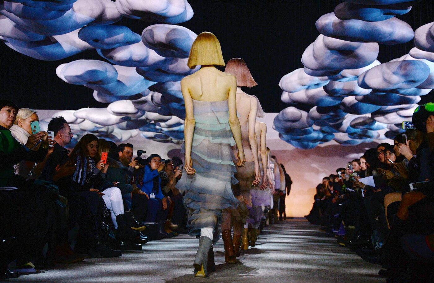 Models walking a Marc Jacobs runway beneath a sculptural installation