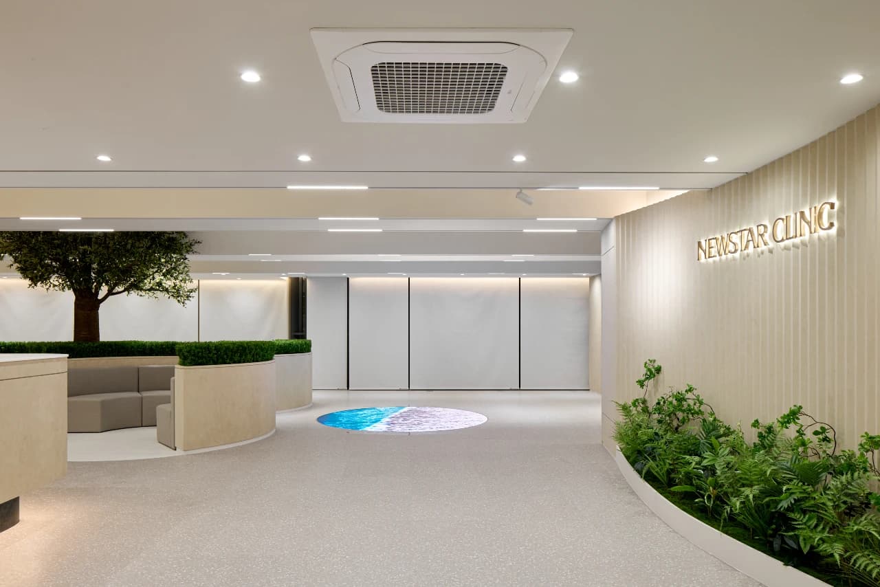 Reception lobby at Newstar Clinic, Gangnam, with greenery and gold signage
