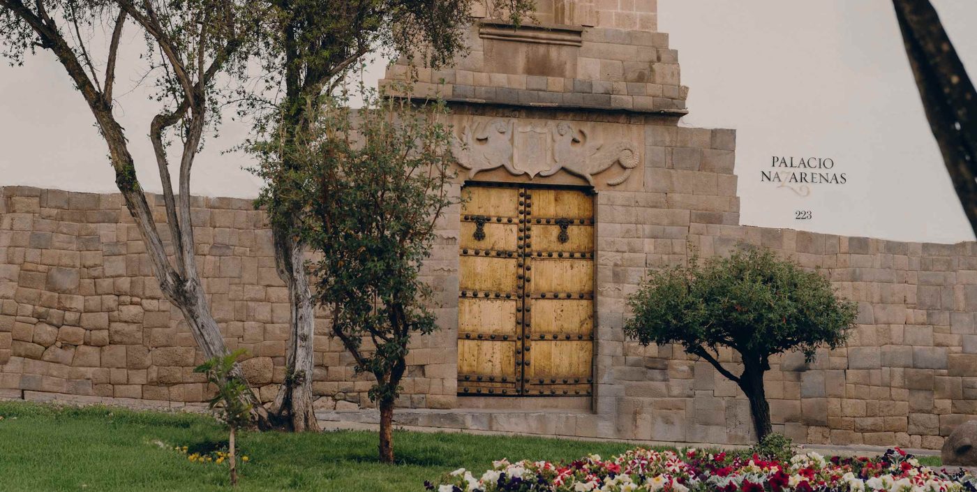 The gilded studded door set in an Inca-stone wall at the entrance to Palacio Nazarenas, A Belmond Hotel in Cusco