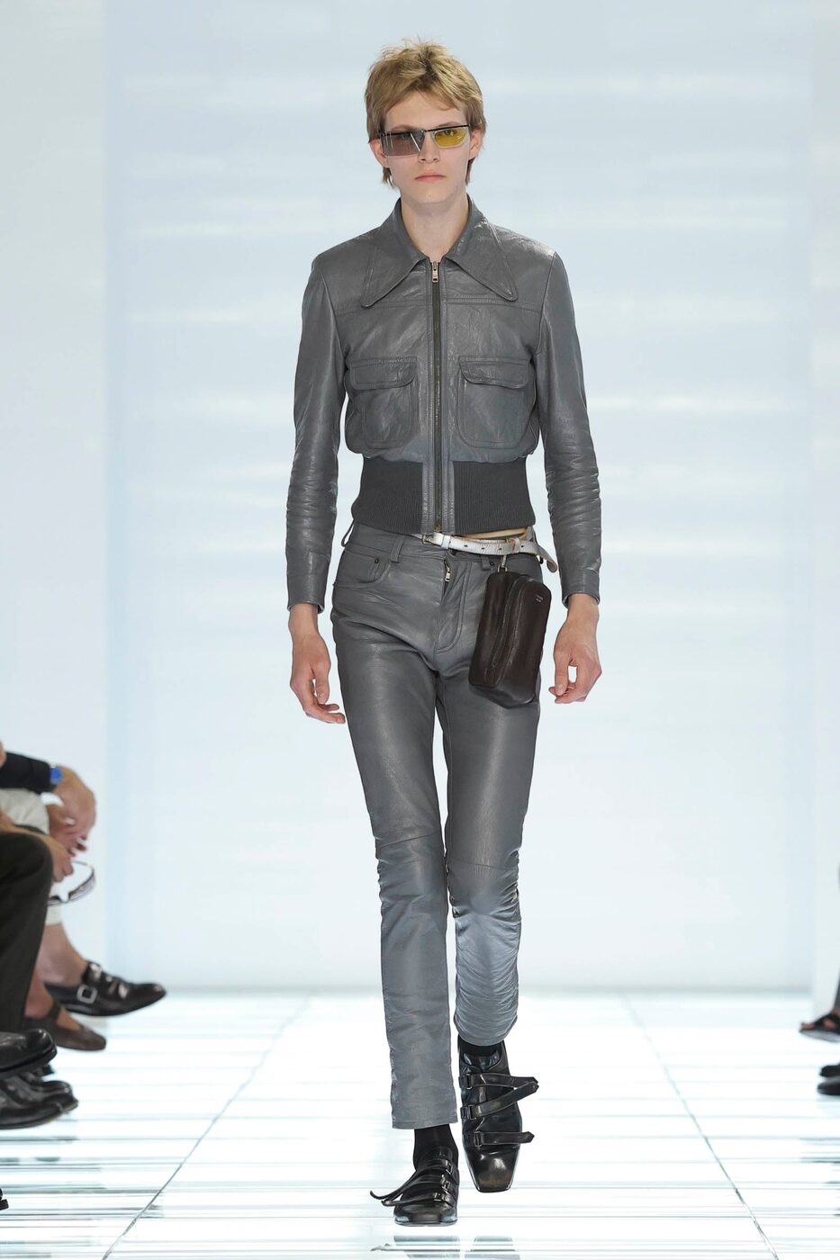 Prada Spring/Summer 2027, a grey leather blouson worn over slim grey leather trousers with a hip bag