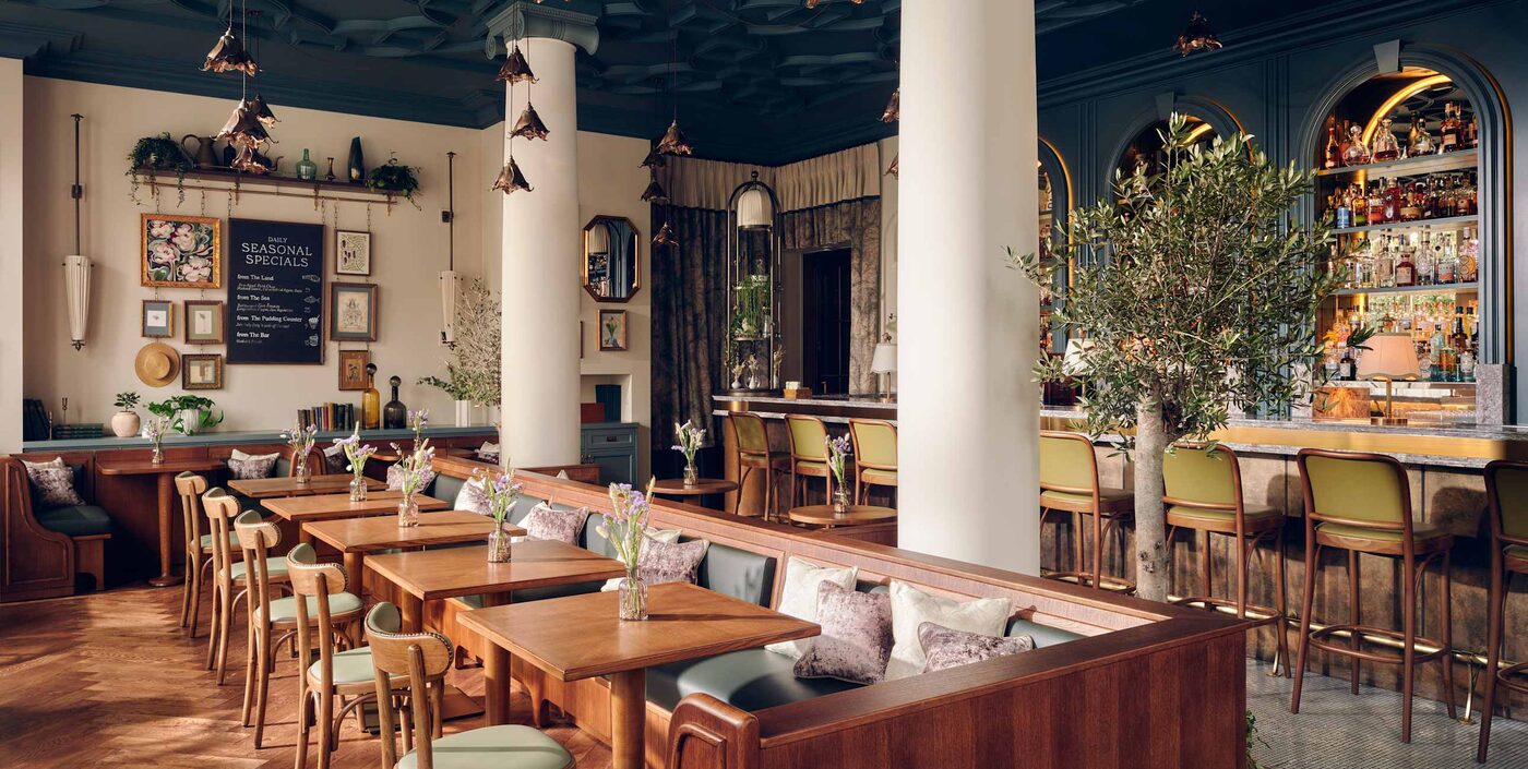 The bar at Willett's, with copper pendant lights and an olive tree, at The Cadogan, A Belmond Hotel, London